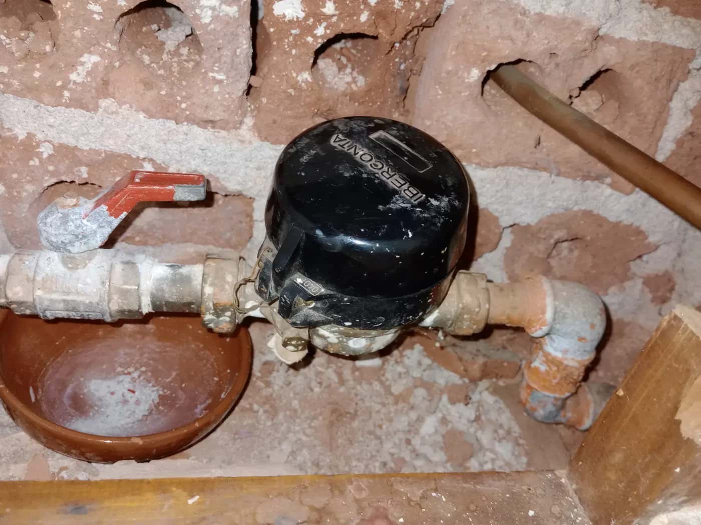 Contador de agua con su llave de paso en la hornacina